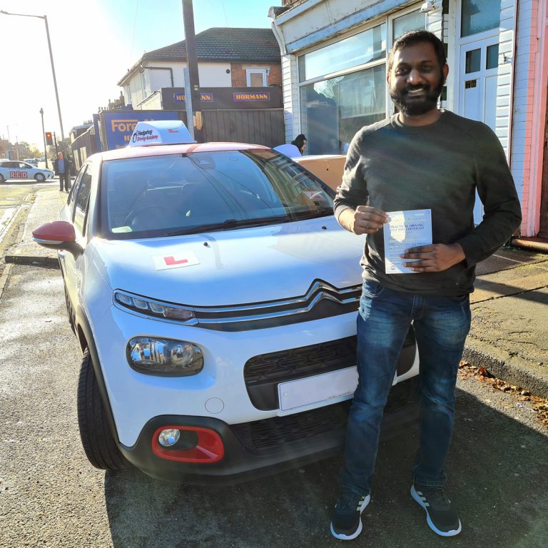 A student holding their pass certificate in front of the Hedgehog Driving Academy car