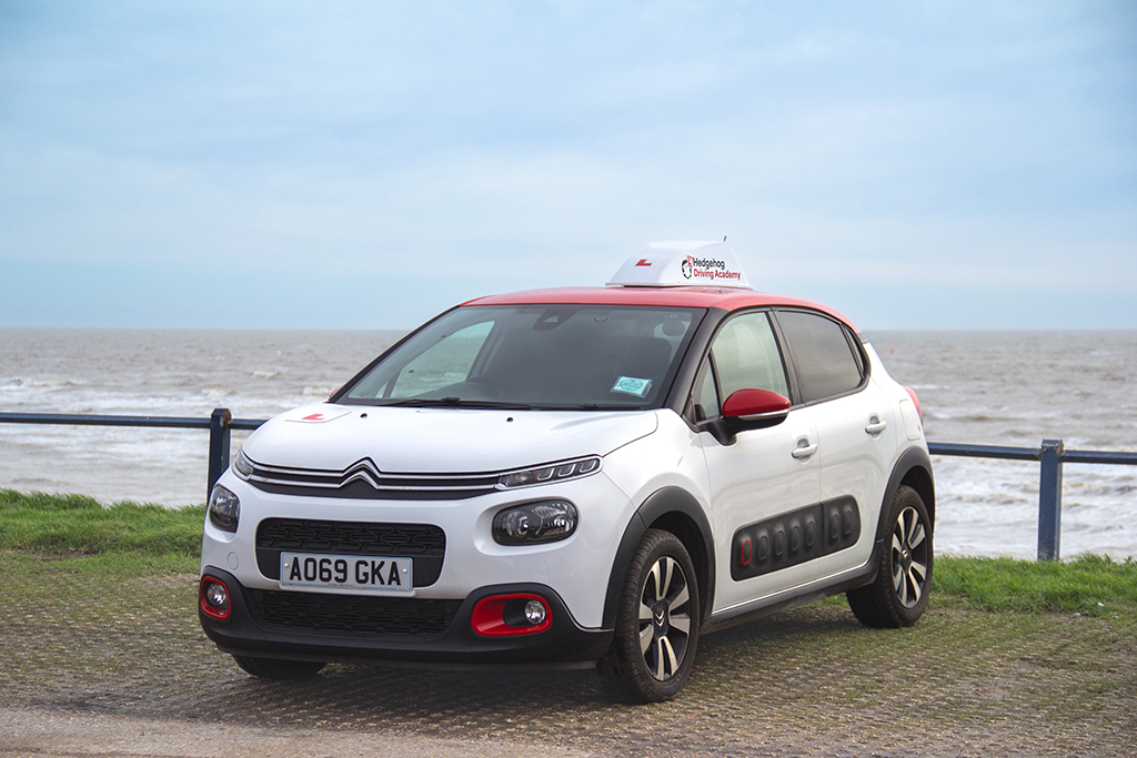 Hedgehog Driving Academy car in front of the sea in Felixstowe