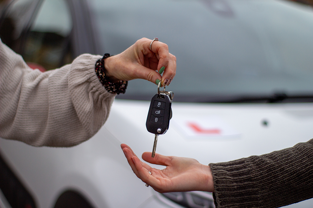 Handing over car keys to student