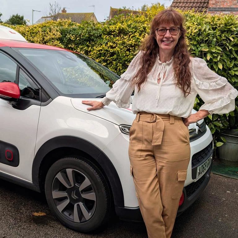 Lisa Marshall stood in front of her driving instructor car